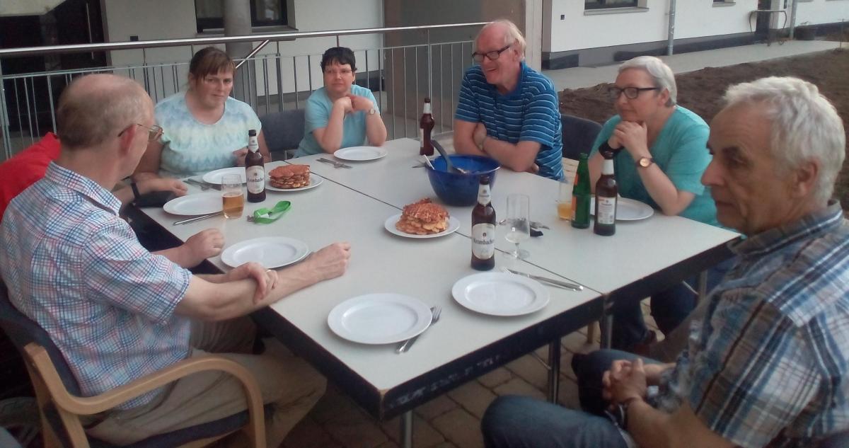 Rund um den Esstisch auf der Terasse vor dem Bewohnercafé